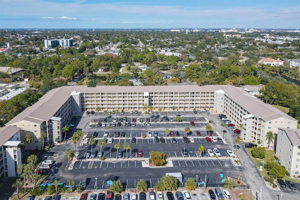 An aerial view shows a large U-shaped apartment complex surrounding a paved parking lot — 3534 LAKE BAYSHORE DRIVE UNIT K118, BRADENTON, FL