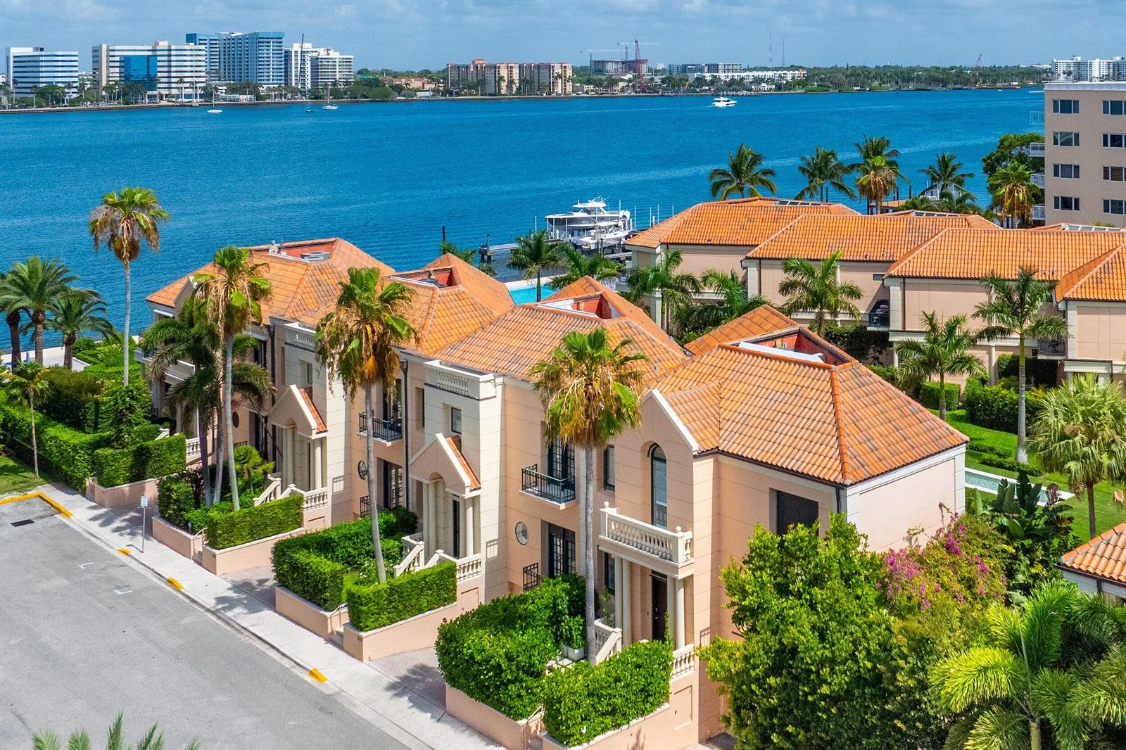 An aerial view of waterfront townhouses with terracotta roofs, palm trees, and a nearby bay — 307 Everglade Avenue, Palm Beach FL 33480, PALM BEACH, FL