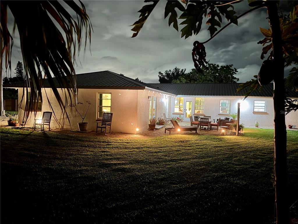 A single-story house with a metal roof and illuminated patio at night — 4620 7TH AVENUE W, BRADENTON, FL