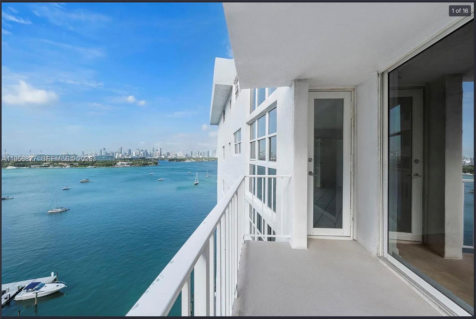 A balcony with a white metal railing overlooks a bay with boats and a city skyline — 1228 West Ave # 1415, Miami Beach FL 33139, MIAMI BEACH, FL