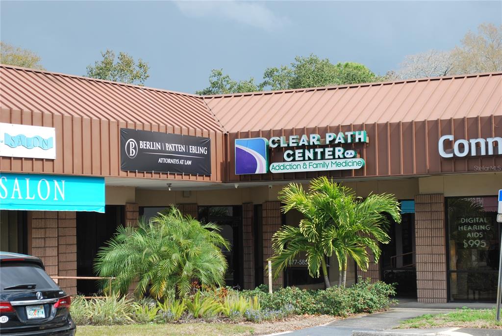 The exterior of a commercial strip mall features several business signs under a brown roof — 3185 4TH STREET N, ST PETERSBURG, FL
