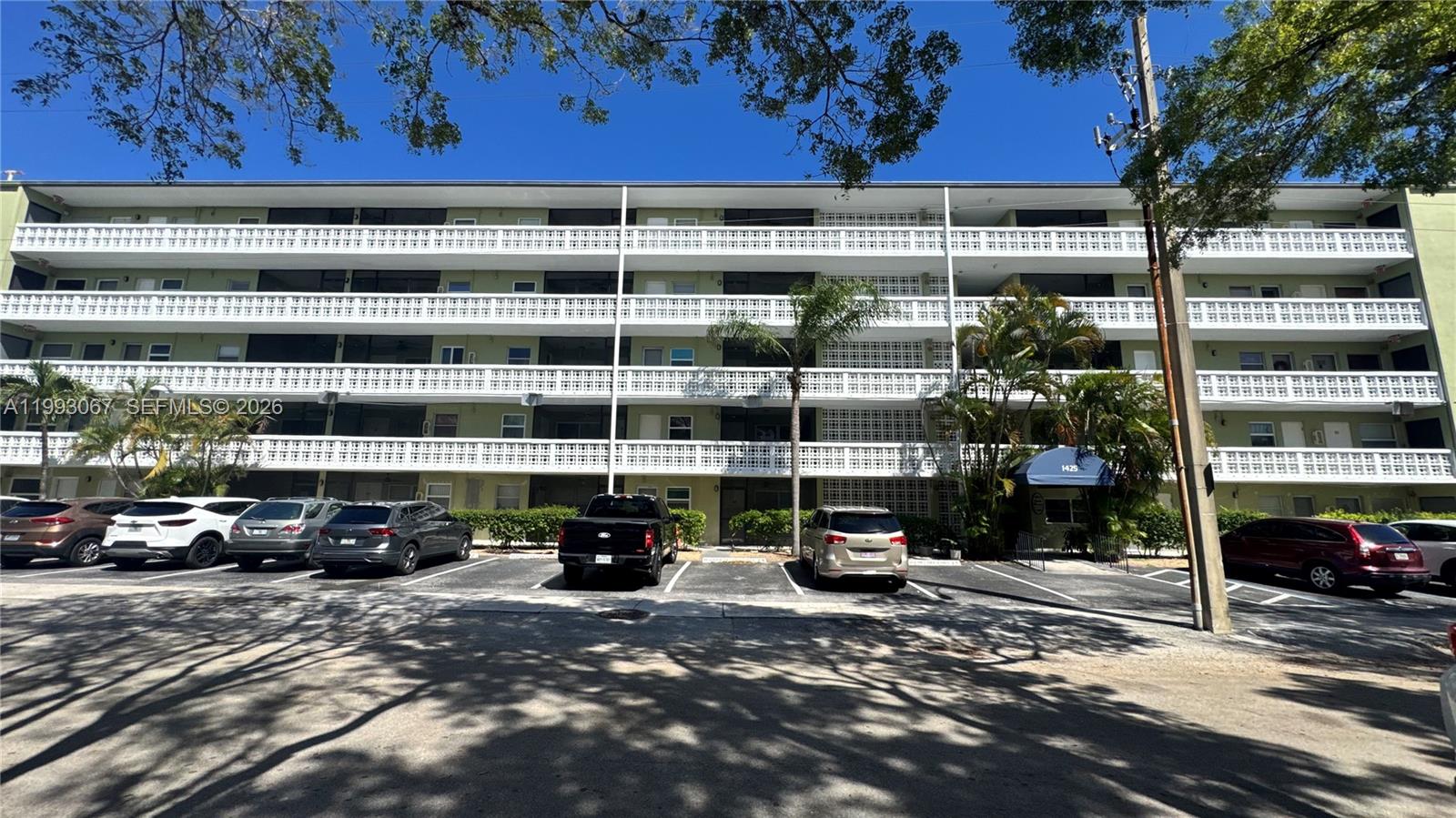 A multi-story apartment building features white balconies and a parking lot in front — 1425 Arthur # 514B, Hollywood FL 33020, HOLLYWOOD, FL