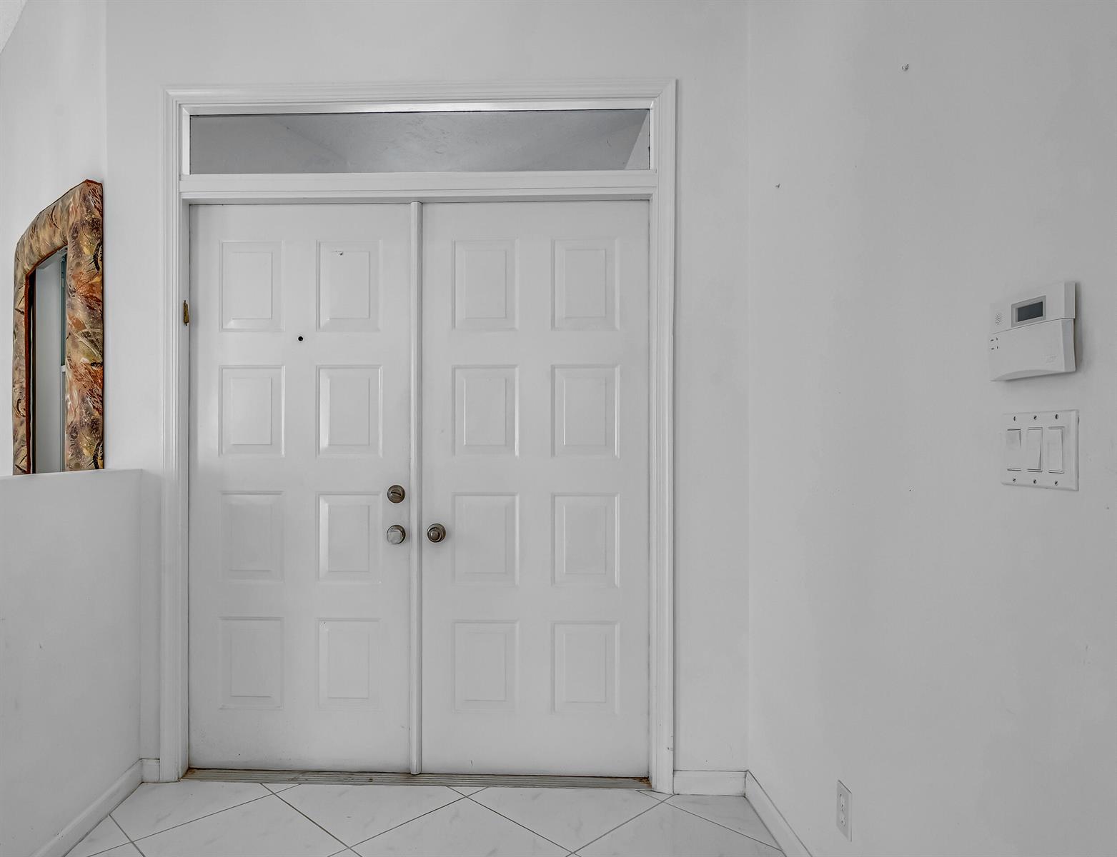 A white double front door with a transom window sits in a tiled entryway — 9758 Harbour Lake Circle, Boynton Beach FL 33437, BOYNTON BEACH, FL