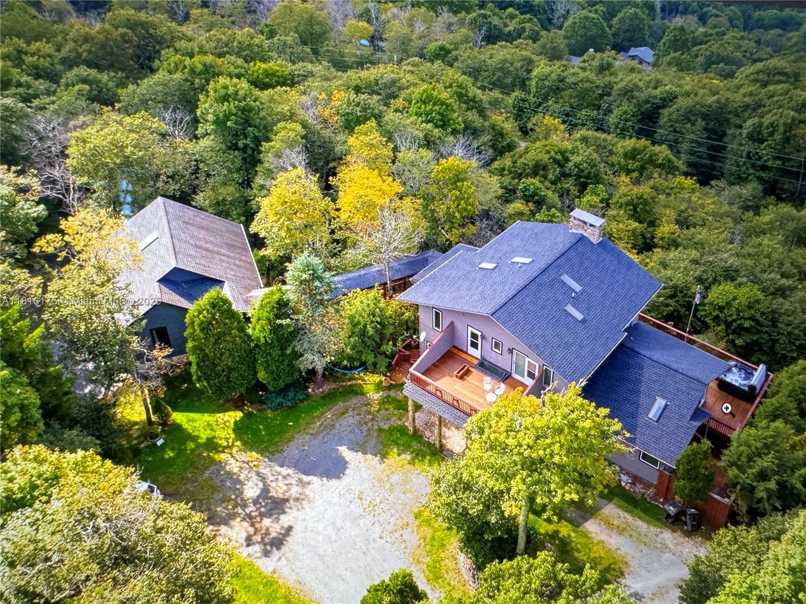 An aerial view shows two houses connected by a walkway surrounded by dense green trees — 200 Summit Lodge Road, NC 28604, NC