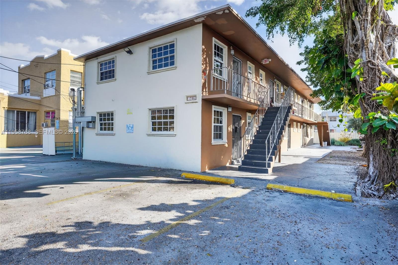 A two-story apartment building with a brown exterior, external staircase, and a paved parking lot — 1736 NW 19th St, Miami FL 33125, MIAMI, FL
