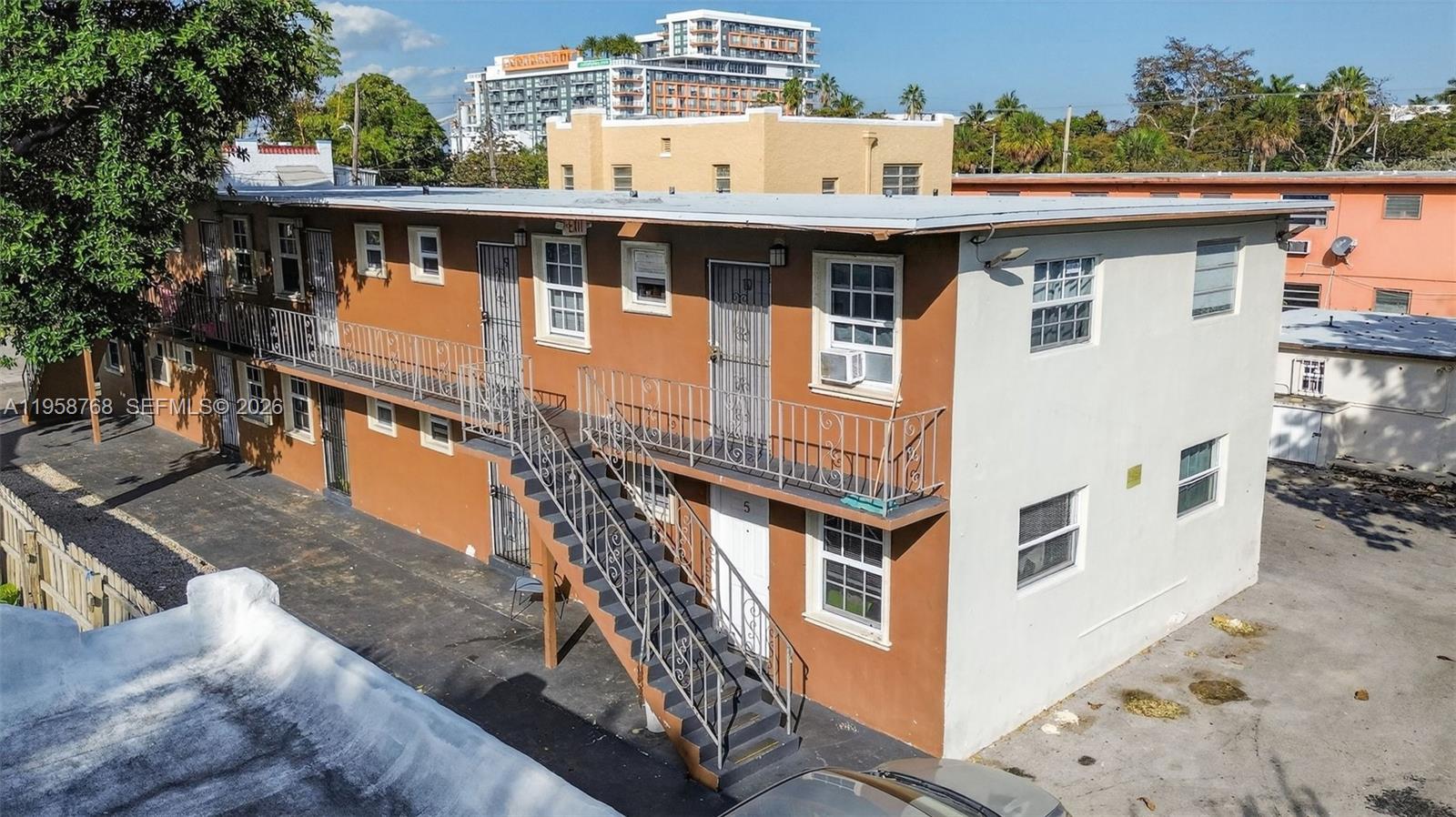 An exterior view of a two-story apartment building with brown and white stucco walls — 1736 NW 19th St, Miami FL 33125, MIAMI, FL