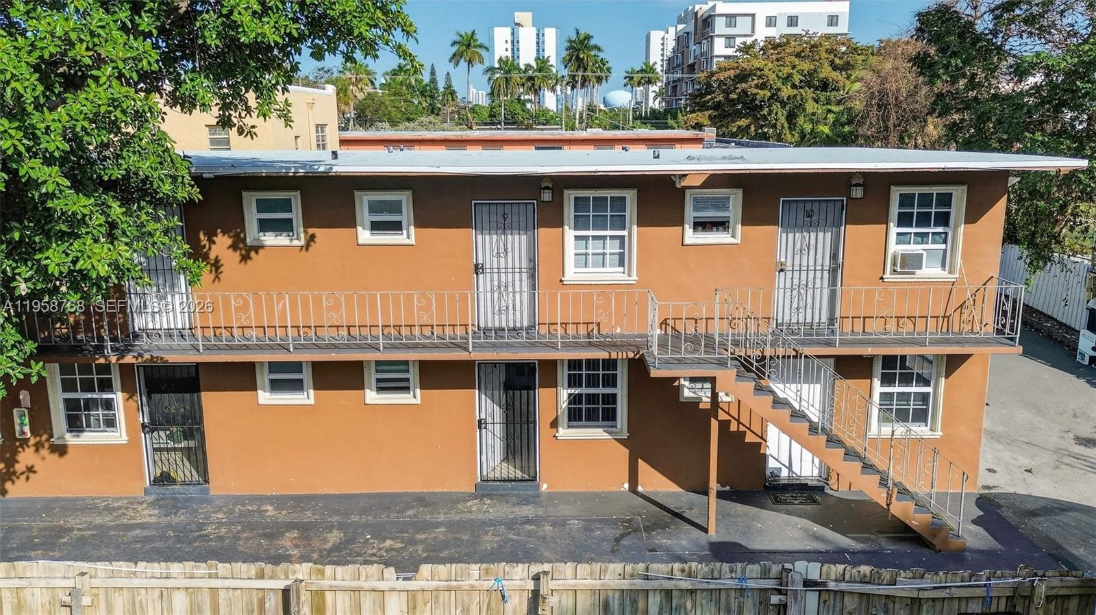 An exterior view of a two-story apartment building with a metal balcony and staircase — 1736 NW 19th St, Miami FL 33125, MIAMI, FL