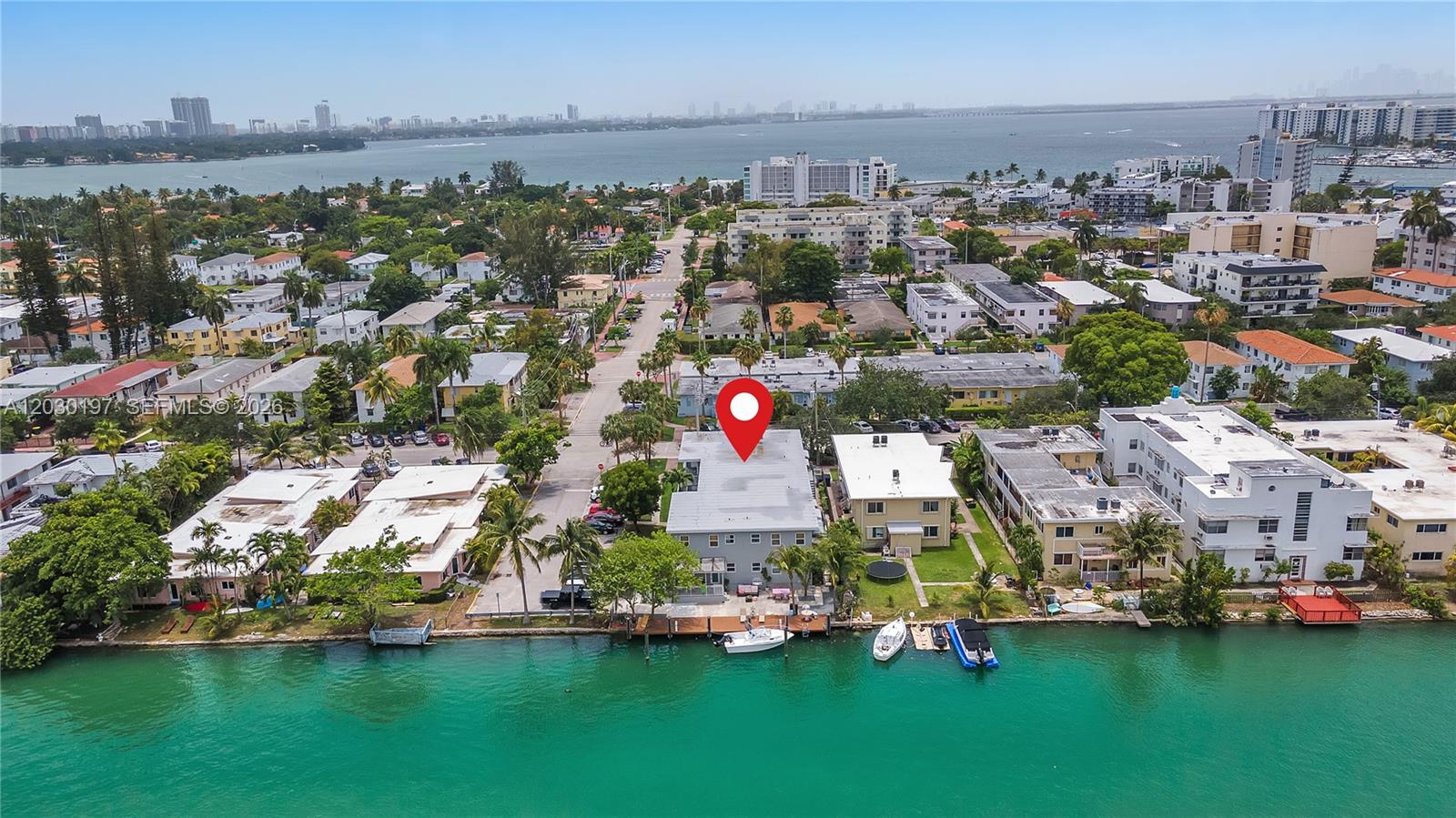 An aerial view shows a waterfront apartment building with a dock and boat slips — 1905 Calais Dr # 6, Miami Beach FL 33141, MIAMI BEACH, FL