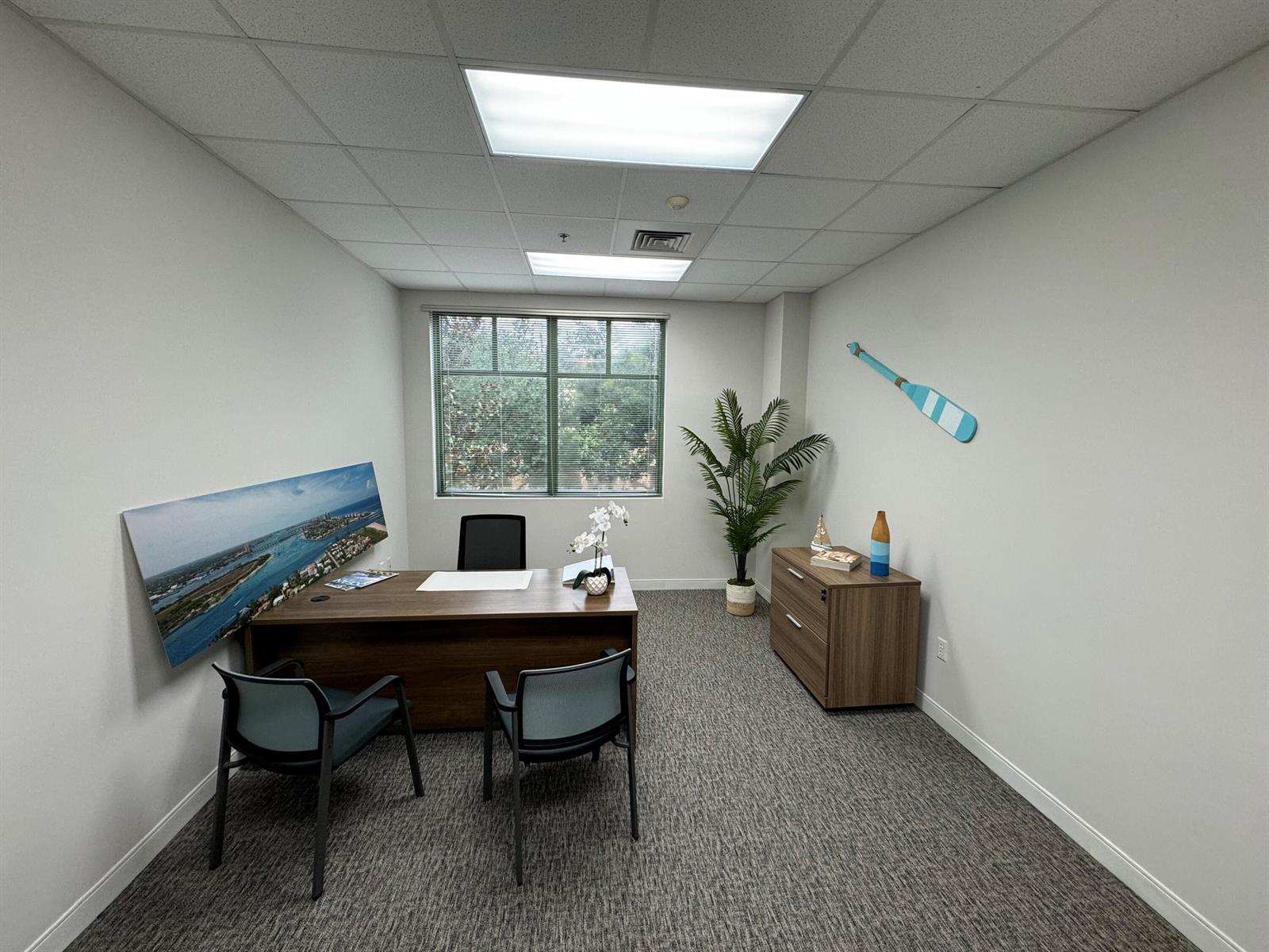 A small office features a wooden desk, two guest chairs, a filing cabinet, and wall decor — 601 Heritage Drive, Jupiter FL 33458, JUPITER, FL