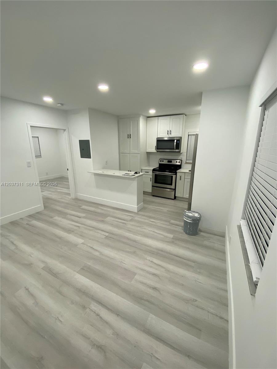 A kitchen with white cabinets, stainless steel appliances, and light wood-look flooring — 3071 SW 27th Ave # 4, Miami FL 33133, MIAMI, FL