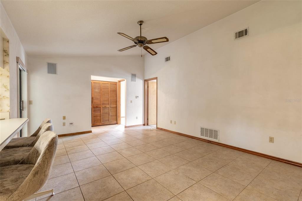 A spacious room with tiled floors, a ceiling fan, and a breakfast bar — 4576 PHIPPS DRIVE, PORT ORANGE, FL