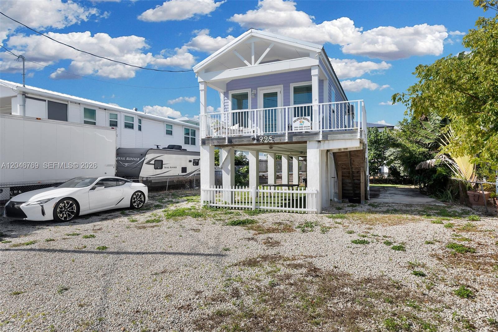 An elevated light purple house stands on stilts above a gravel lot with a white car — 925 83rd Street Ocean, Marathon FL 33050, MARATHON, FL
