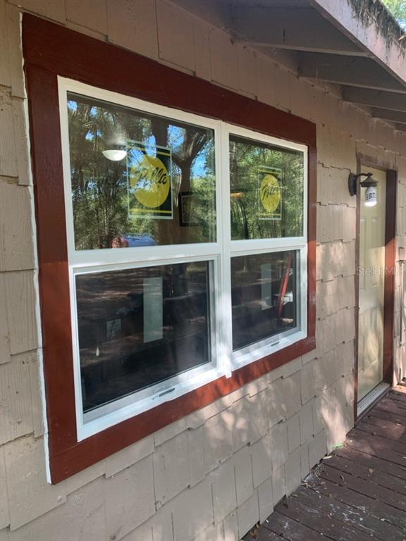 A tan shingled exterior wall features a new Pella window with dark red trim — 4919 NE 18 TRAIL, TRENTON, FL