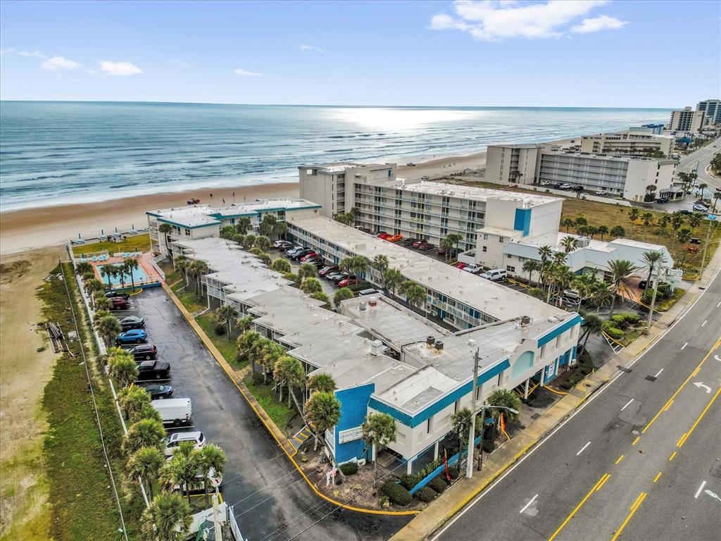 An aerial view of a multi-story beachfront hotel complex with a parking lot and pool — 935 S ATLANTIC AVENUE UNIT 239, DAYTONA BEACH, FL