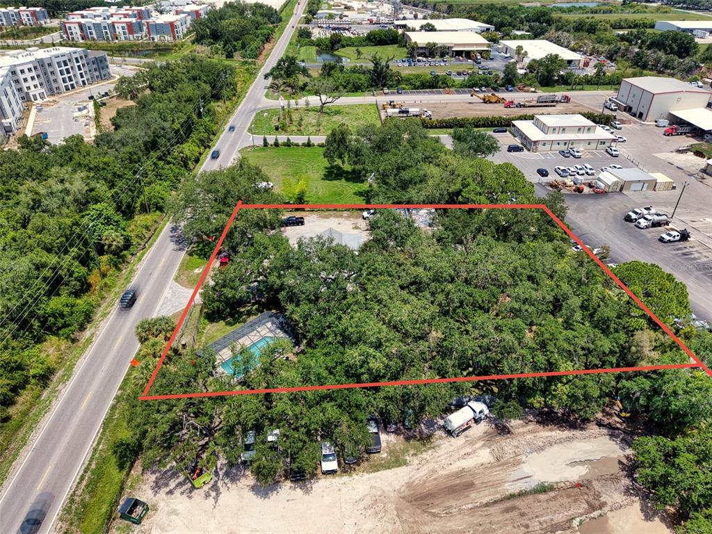 An aerial view shows a wooded property with a swimming pool outlined in red — 4727 15TH STREET E, BRADENTON, FL
