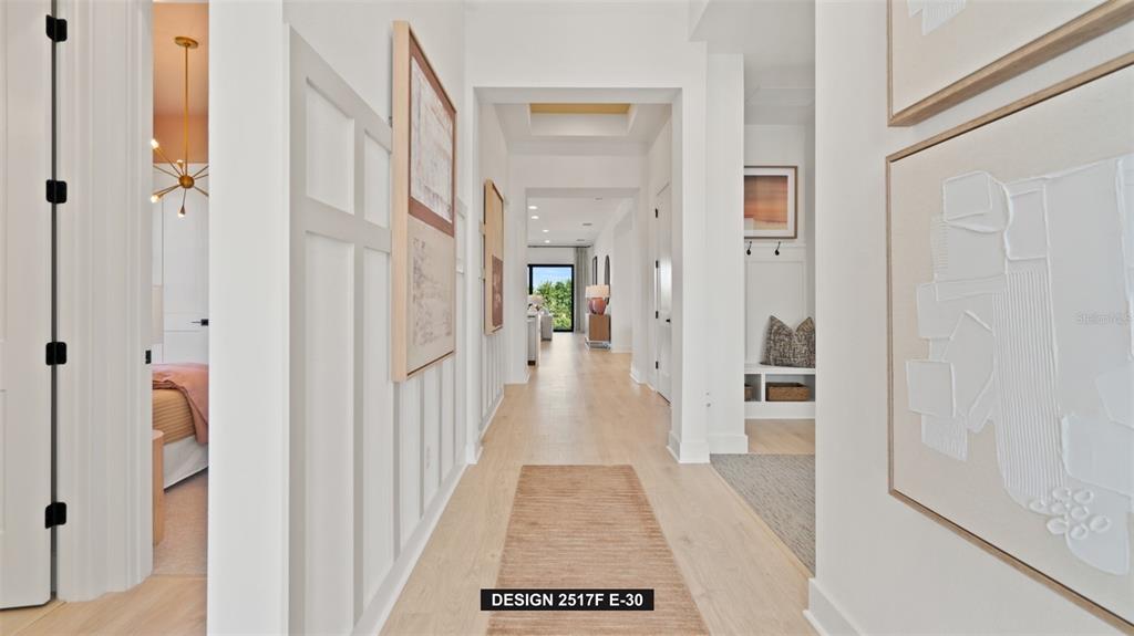 A bright hallway features light wood floors, white walls, and textured wall art — 383 SUN CHASER DRIVE, NOKOMIS, FL