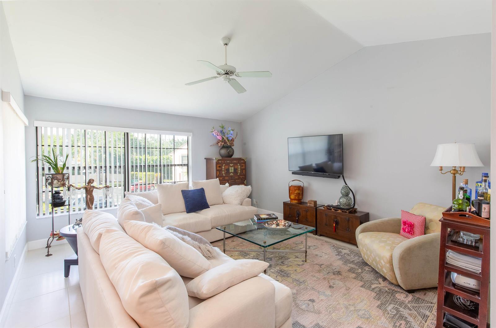 A living room features a white sofa, a patterned rug, a television, and a ceiling fan — 3399 Jog Park Drive, FL 33467, FL