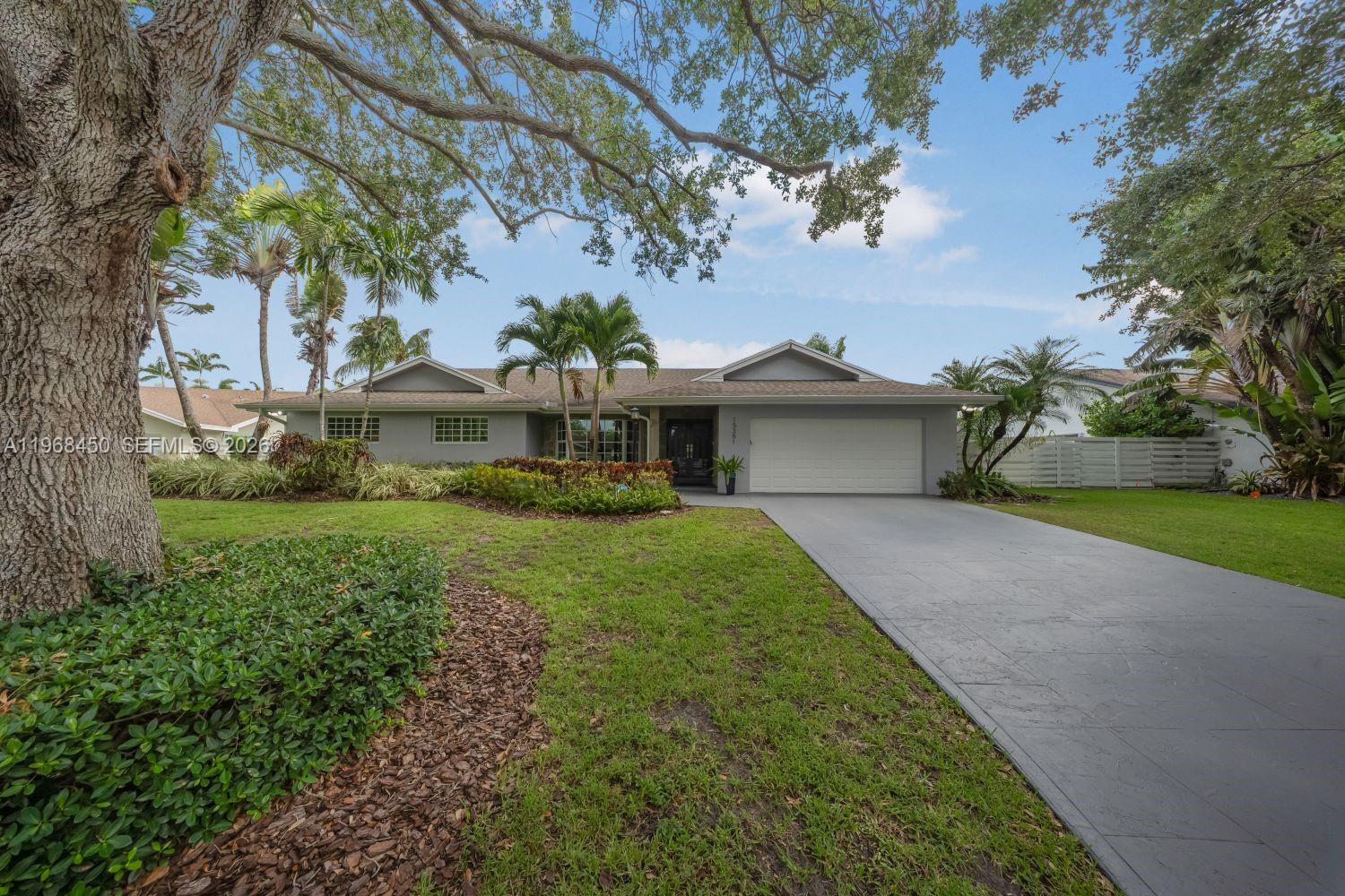 A single-story house with a gray exterior, a two-car garage, and a large front lawn — 12208 SW 220 ST, Miami FL 33170, MIAMI, FL