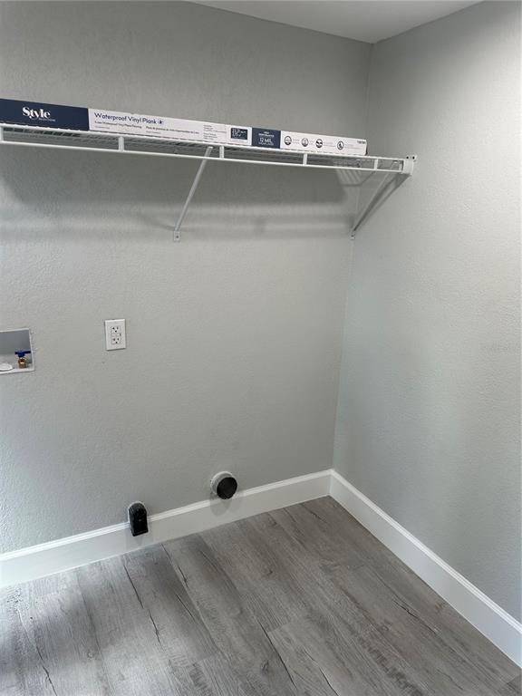 A laundry room with gray walls, wood-look vinyl flooring, and a white wire shelf — 507 STONE STREET, WILDWOOD, FL