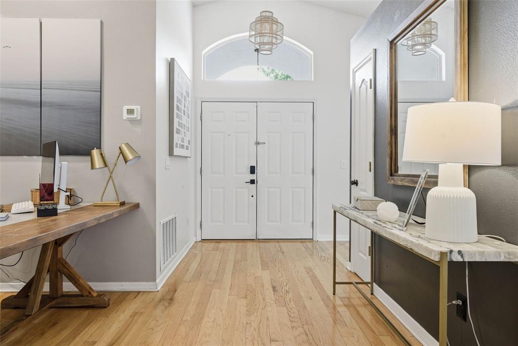 An entryway features hardwood floors, a double front door, a desk, and a console table — 13917 TALLOWRIDGE COURT, ORLANDO, FL
