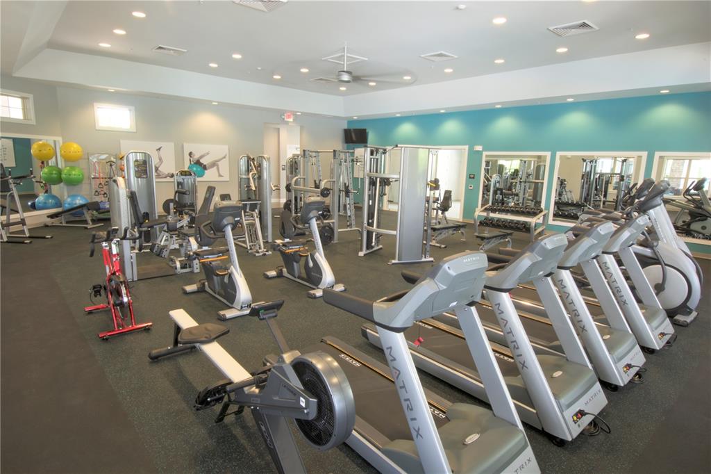 A gym features multiple Matrix treadmills, a rowing machine, stationary bikes, and various strength training equipment — 16816 HOBE SOUND COURT, WINTER GARDEN, FL