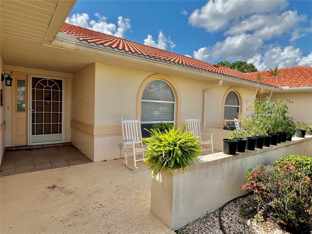 A beige house exterior features a tiled roof, arched windows, and a front patio area — 3805 CATALINA DRIVE UNIT 3805, SEBRING, FL