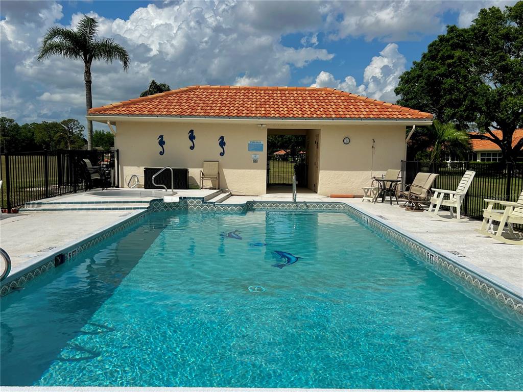 A rectangular swimming pool sits in front of a building with a tiled roof — 3805 CATALINA DRIVE UNIT 3805, SEBRING, FL