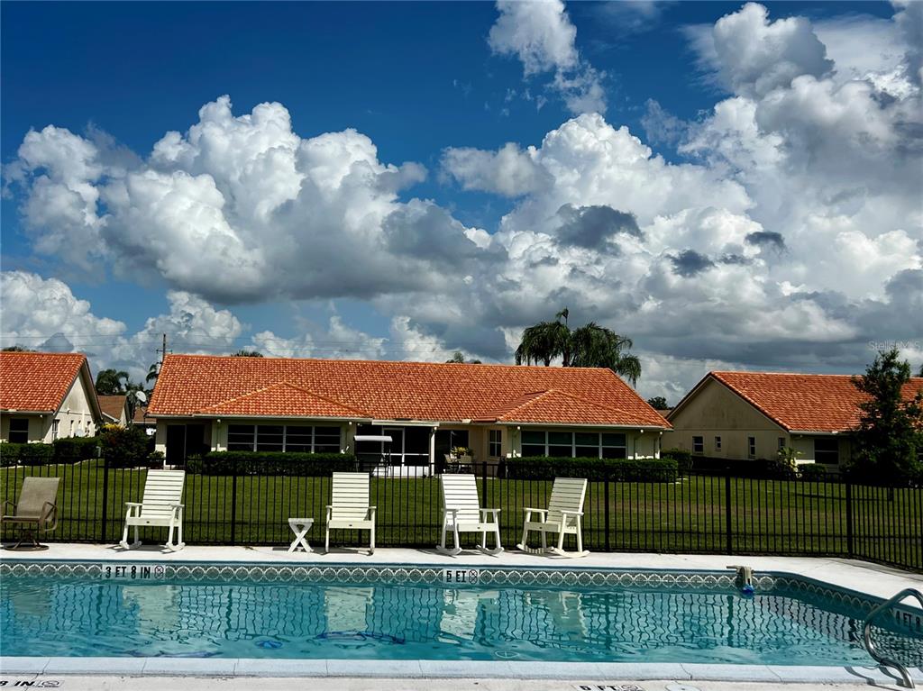 A swimming pool sits in front of a house with a red tile roof — 3805 CATALINA DRIVE UNIT 3805, SEBRING, FL