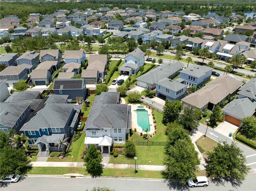 An aerial view shows a suburban neighborhood with houses, a swimming pool, and streets — 9051 SPERRY STREET, ORLANDO, FL