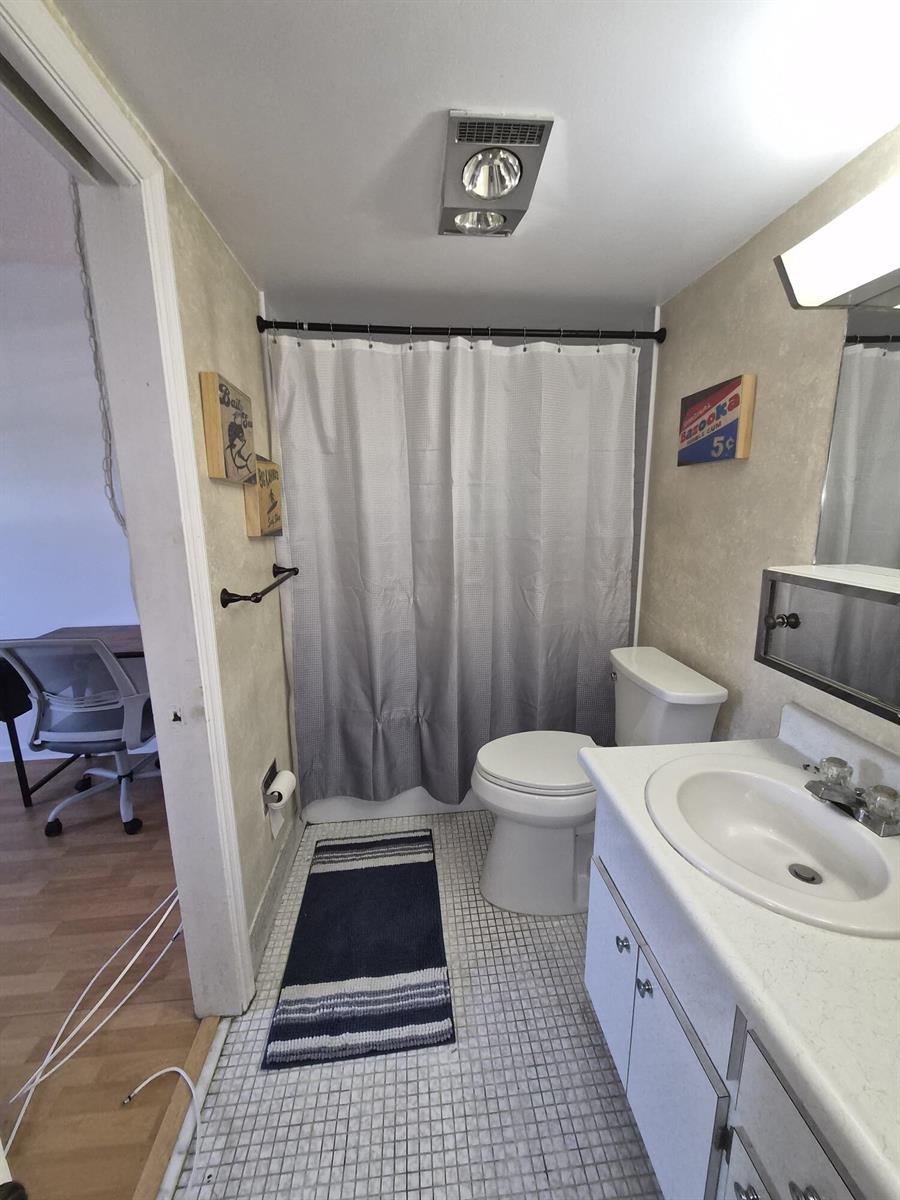 A bathroom features a shower with a grey curtain, a toilet, and a vanity sink — 100 Royal Palm Way # 2040, Boca Raton FL 33432, BOCA RATON, FL