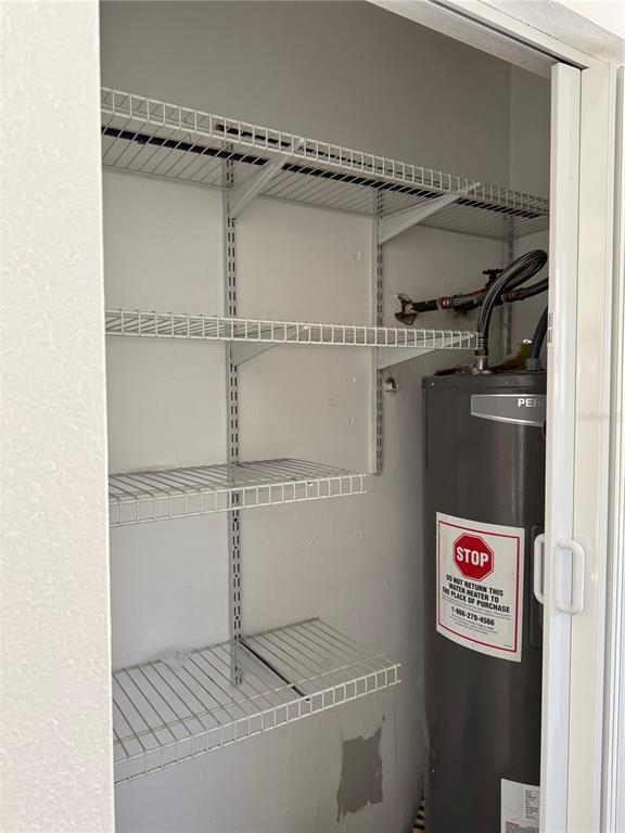 A utility closet contains wire shelving and a water heater — 425 HOLLYHOCK LANE, SPRING HILL, FL