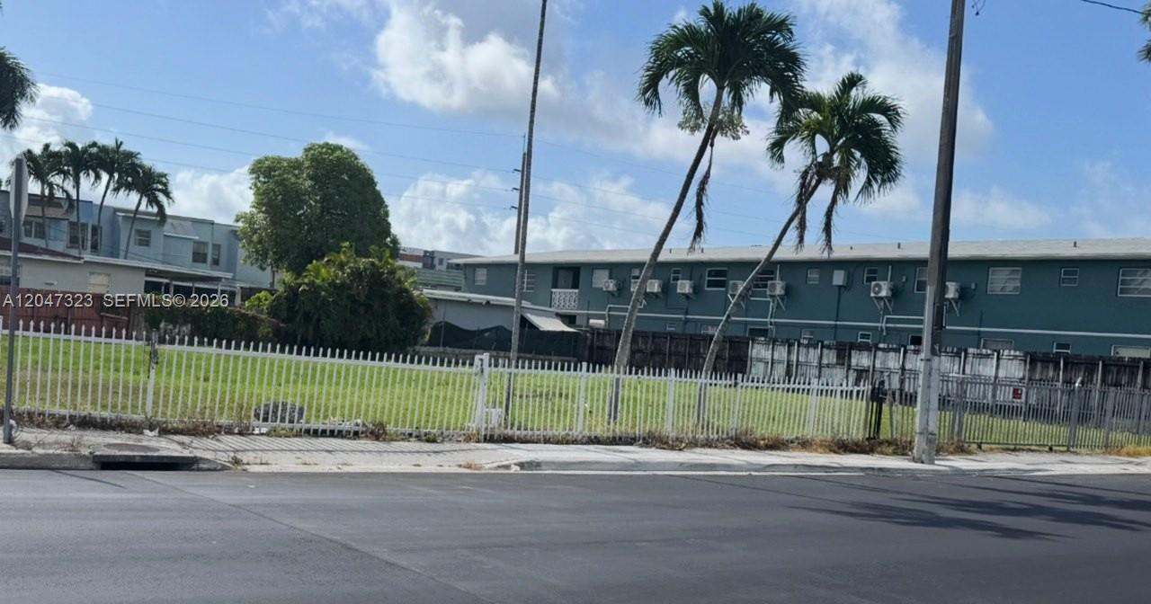 A fenced, vacant grassy lot sits in front of a multi-story apartment building — 895 NW 45th Ave, Miami FL 33126, MIAMI, FL