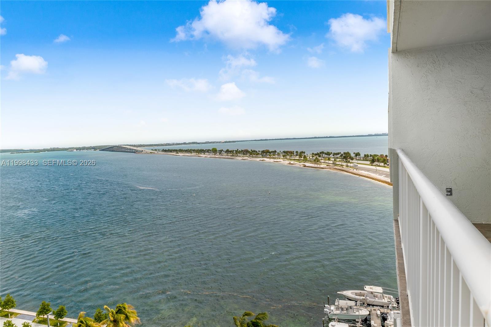 A high-angle view from a balcony overlooks a bay, a bridge, and docked boats — 150 SE 25th Rd # 12B, Miami FL 33129, MIAMI, FL