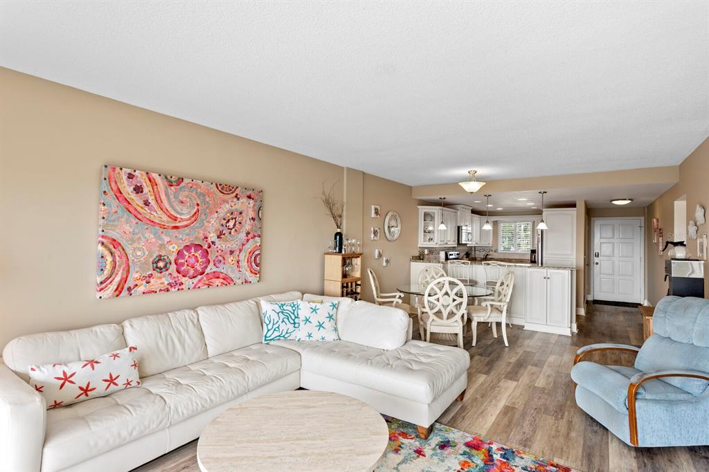 A living room with a white sectional sofa, a round coffee table, and an open kitchen — 1200 N SHORE DRIVE NE UNIT 407, ST PETERSBURG, FL