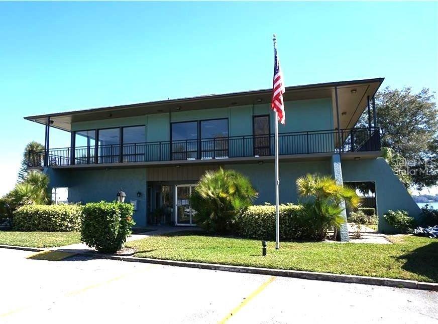A two-story teal commercial building features a second-floor balcony and an American flag — 2500 21ST STREET NW UNIT 15, WINTER HAVEN, FL