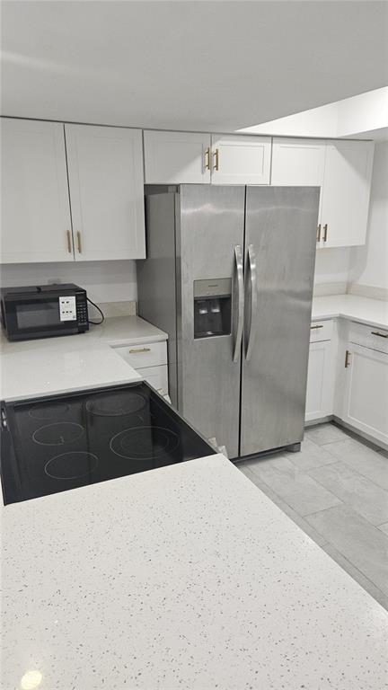 A kitchen features white cabinets, stainless steel appliances, and light-colored quartz countertops — 2500 21ST STREET NW UNIT 15, WINTER HAVEN, FL