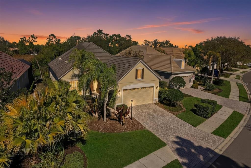An aerial view of a suburban house with a paver driveway and a tiled roof — 7478 EDENMORE STREET, LAKEWOOD RANCH, FL
