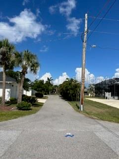 A paved road leads through a residential area with palm trees and houses under a sky — 310 W HENRY STREET, PUNTA GORDA, FL