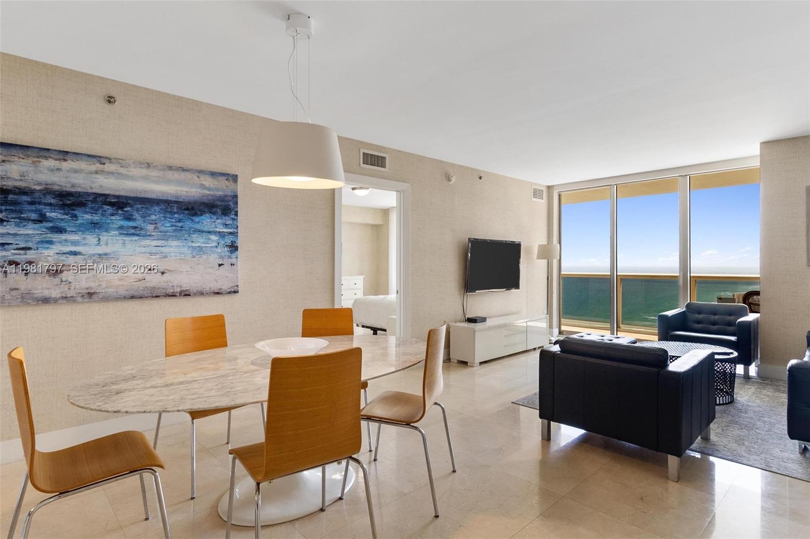 A dining area and living room with ocean views and light tile flooring — 1830 S Ocean Dr # 2904, Hallandale Beach FL 33009, HALLANDALE BEACH, FL