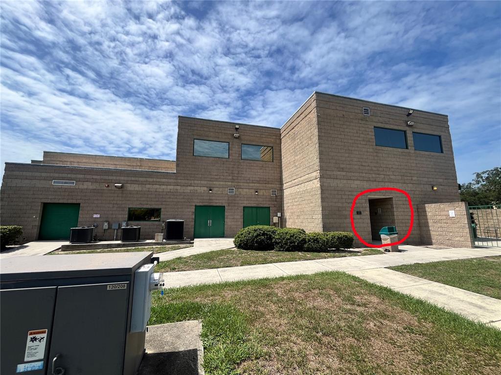 Exterior view of a tan masonry building with green doors and a recessed entrance — 450 W MAIN STREET 2nd Floor, BARTOW, FL