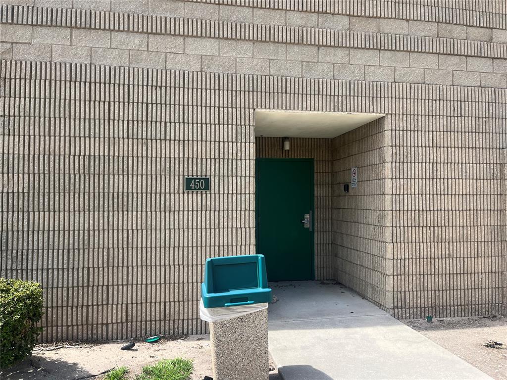 A green door with the number 450 is set into a tan concrete block wall — 450 W MAIN STREET 2nd Floor, BARTOW, FL