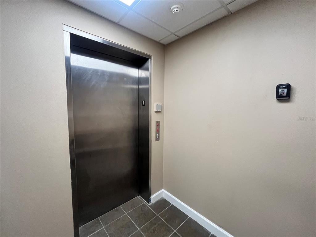 A stainless steel elevator door is set into a beige wall with tiled flooring — 450 W MAIN STREET 2nd Floor, BARTOW, FL