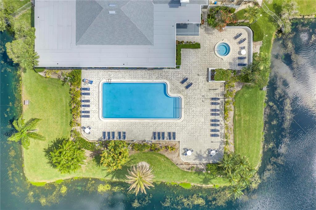 An aerial view shows a swimming pool and hot tub on a paved patio deck — 2333 FEATHER SOUND DRIVE UNIT C201, CLEARWATER, FL