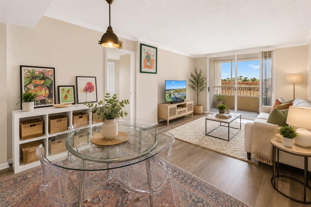 A living and dining area features a glass table, white shelving, and a balcony view — 2333 FEATHER SOUND DRIVE UNIT C201, CLEARWATER, FL