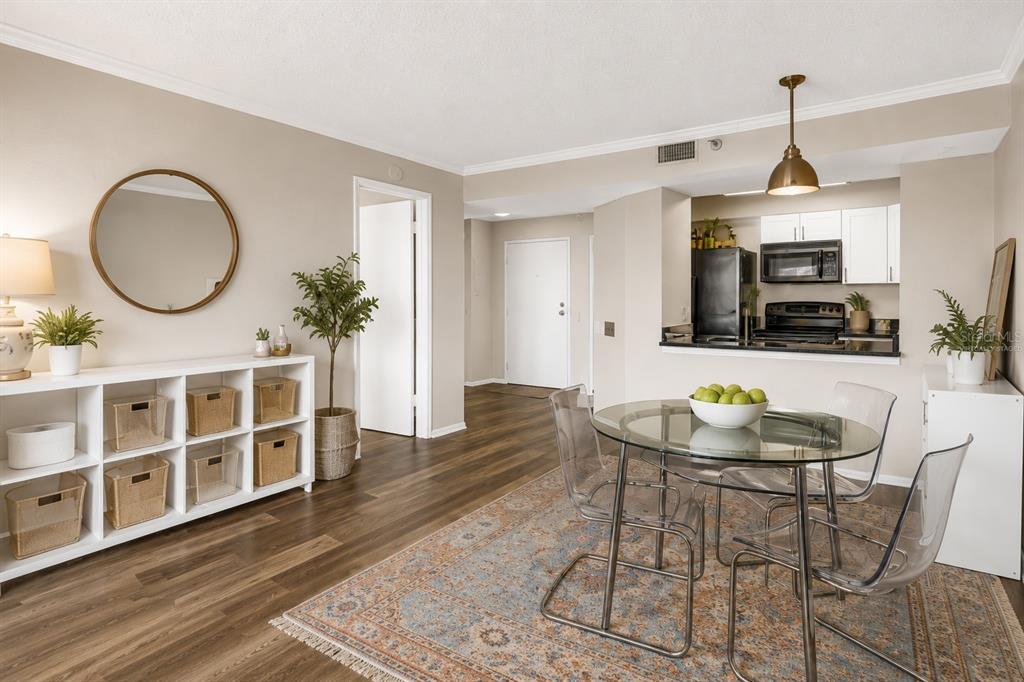 A dining area with a glass table, clear chairs, and a white storage unit — 2333 FEATHER SOUND DRIVE UNIT C201, CLEARWATER, FL