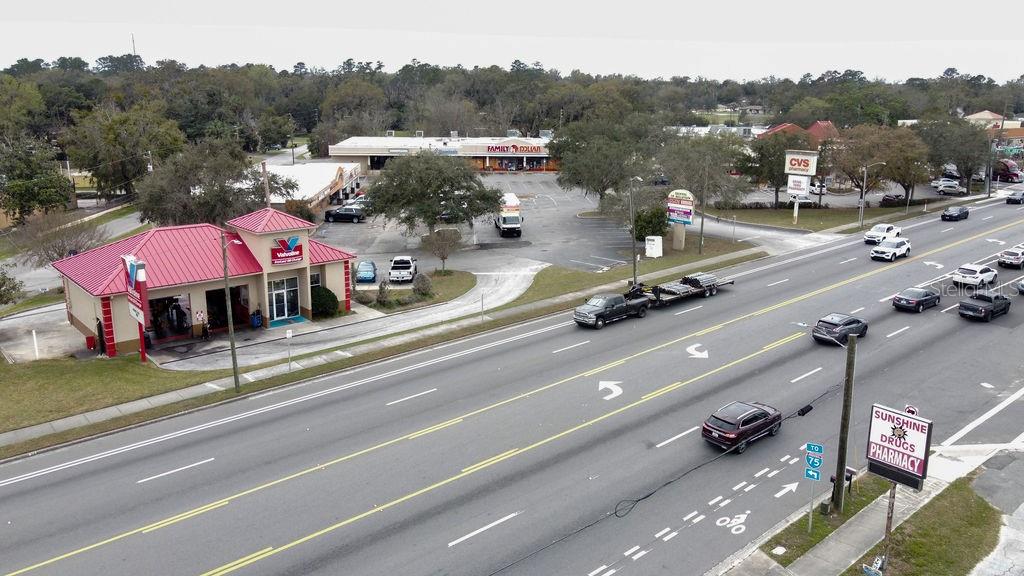 An aerial view shows a commercial street with a Valvoline, Family Dollar, and CVS pharmacy — 5810 SE ABSHIER BOULEVARD, BELLEVIEW, FL