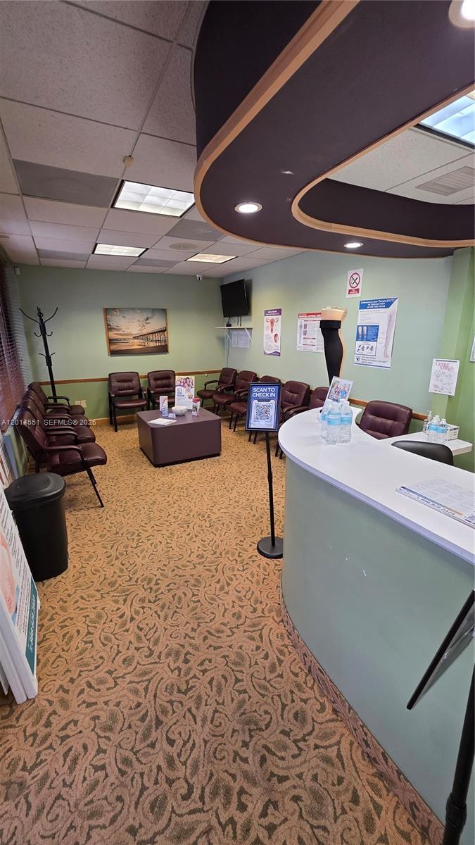 A waiting room features a reception desk, rows of chairs, and patterned carpeting — 5409 N State Road 7, Tamarac FL 33319, TAMARAC, FL