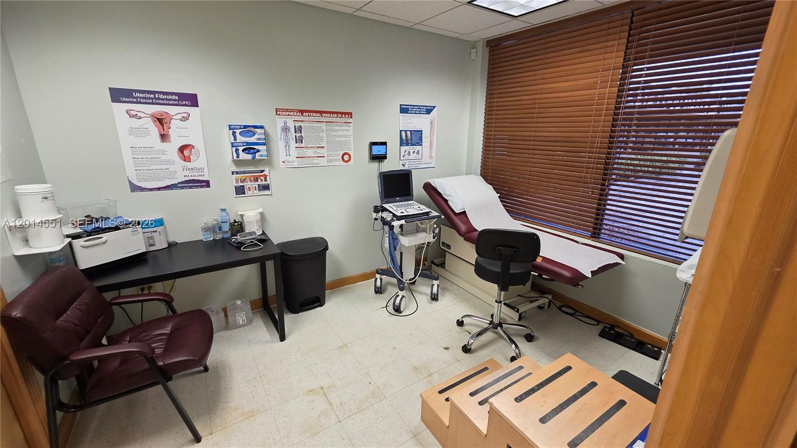 A medical examination room features a treatment table, ultrasound equipment, and educational posters on the walls — 5409 N State Road 7, Tamarac FL 33319, TAMARAC, FL