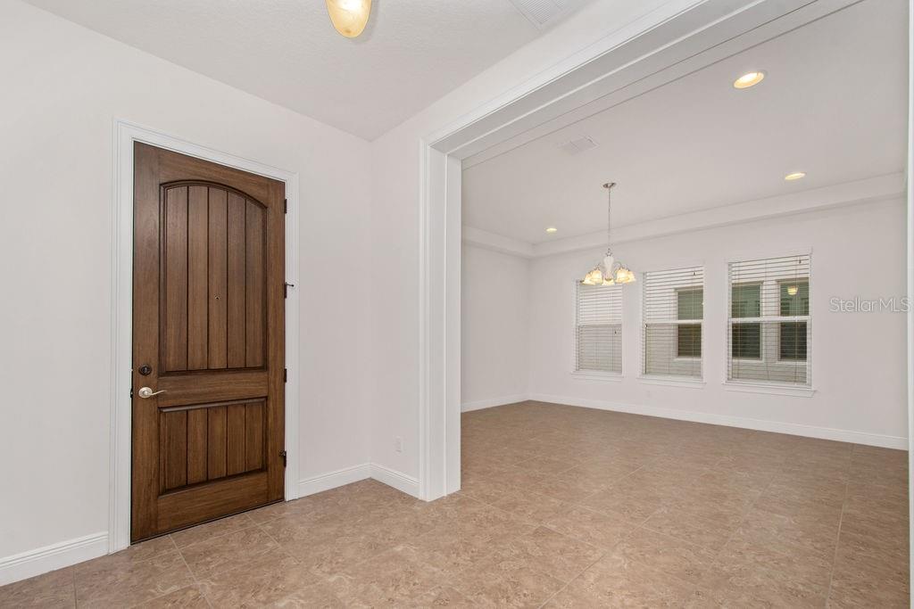 A tiled entryway leads into a dining room with a chandelier and large windows — 17538 BLACK RAIL STREET, WINDERMERE, FL