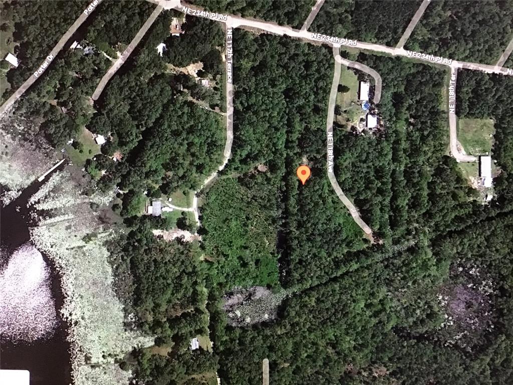This is an aerial map view of a wooded lot with a location pin — PARCEL 0013003044, FORT MC COY, FL